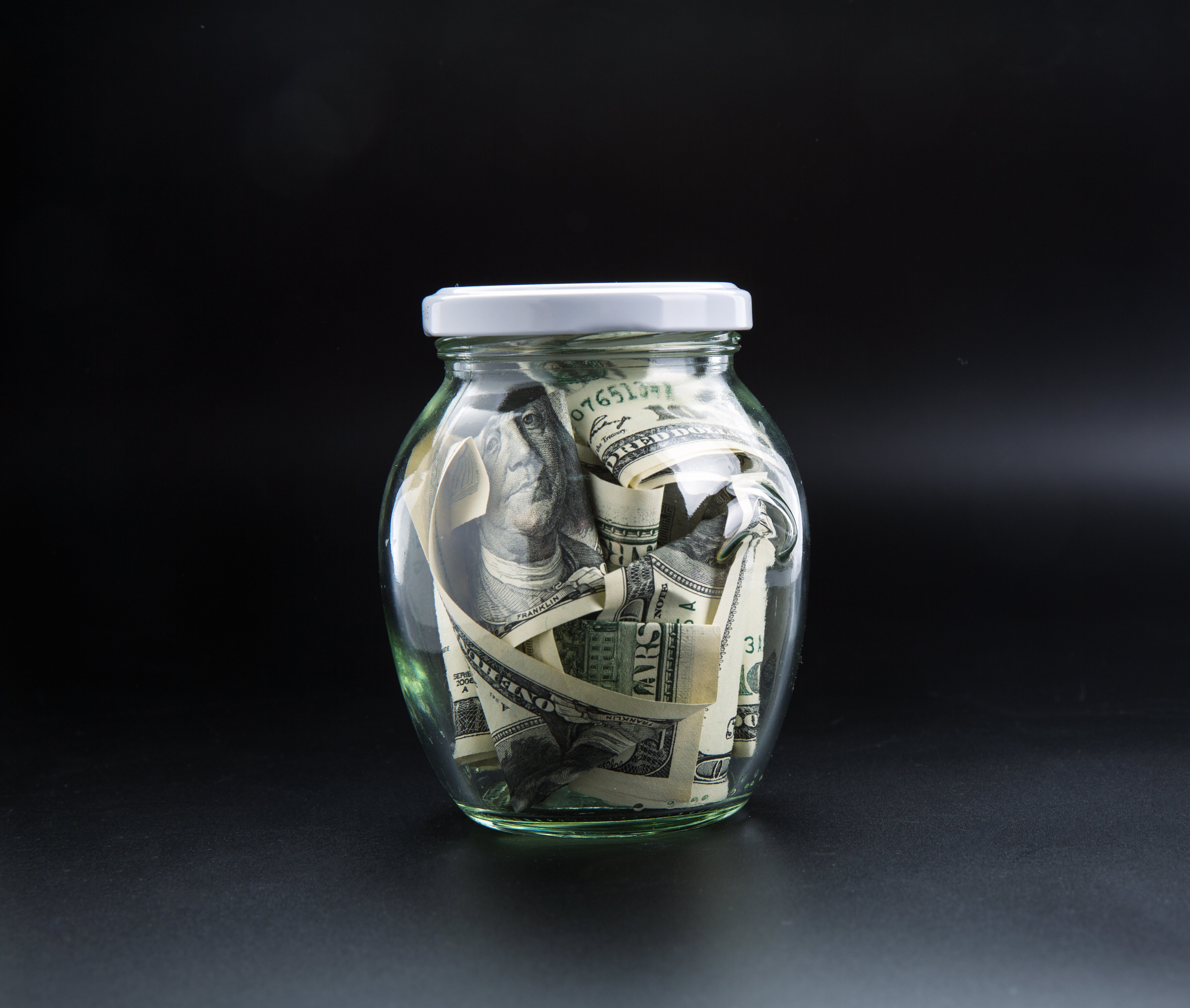 money-saving-concept-glass-jar-full-of-dollars-PWNZMK5